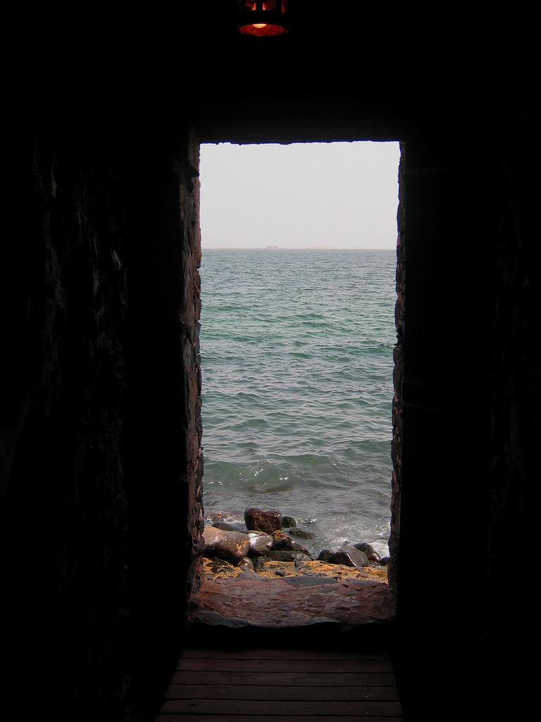 Portal of Sorrow. A small carved exit in a stone wall looks out into the ocean.