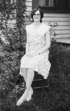 black and white image of a dark-haired young lady sitting on a chair outdoors black and white image of a dark-haired young lady sitting on a chair outdoors