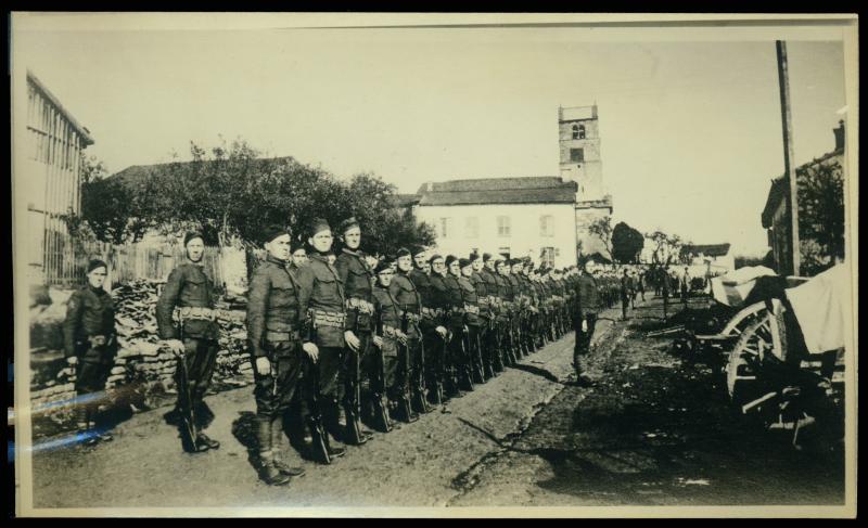 Soldiers stand at attention Photograph of soldiers standing in line. They are on a residential street.