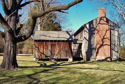 Stagville Plantation Stagville Plantation. Two wooden buildings with a large tree in front. It is a sunny day with blue skies.