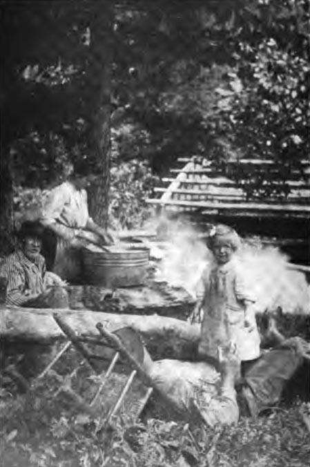 "Let the women do the work" from book A picture of three adults and one child. A man rests while the child plays near him. Another man sits beside the woman while she cooks or cleans.